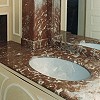 Die Sule oberhalb des Waschbeckens ist ein kleiner Schrank aus Holz und passend zum echten Marmor der Waschtischplatte marmoriert.